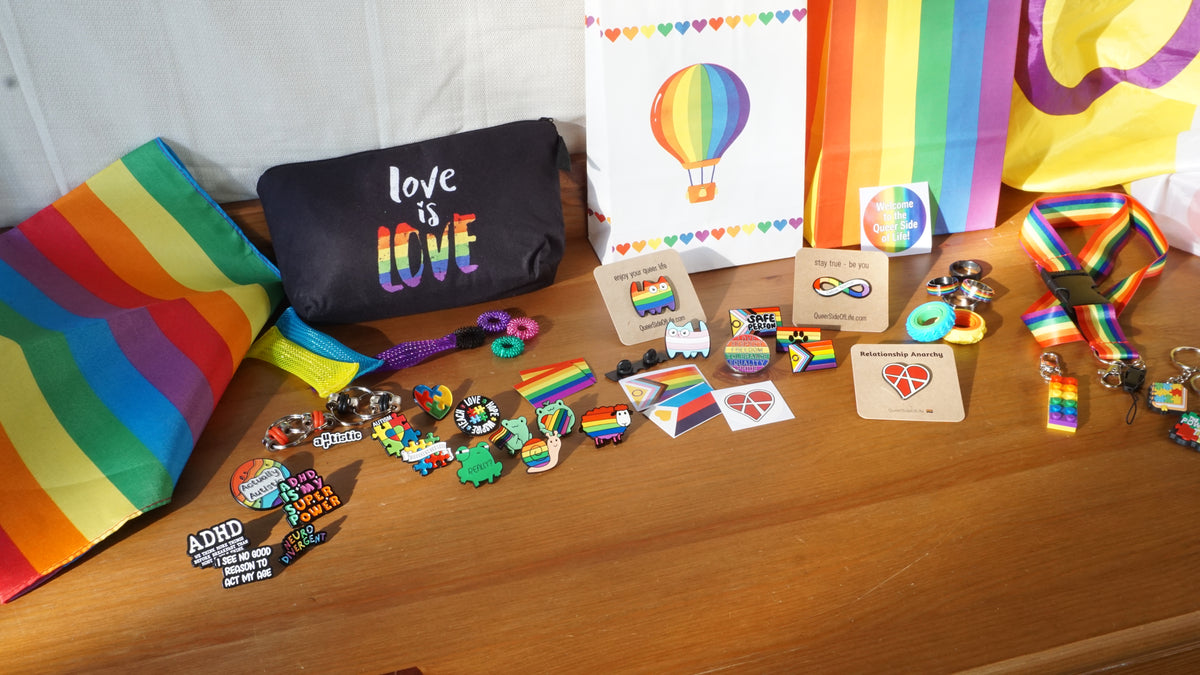 Bunte Pride-Produkte auf einem Holztisch im warmen Licht